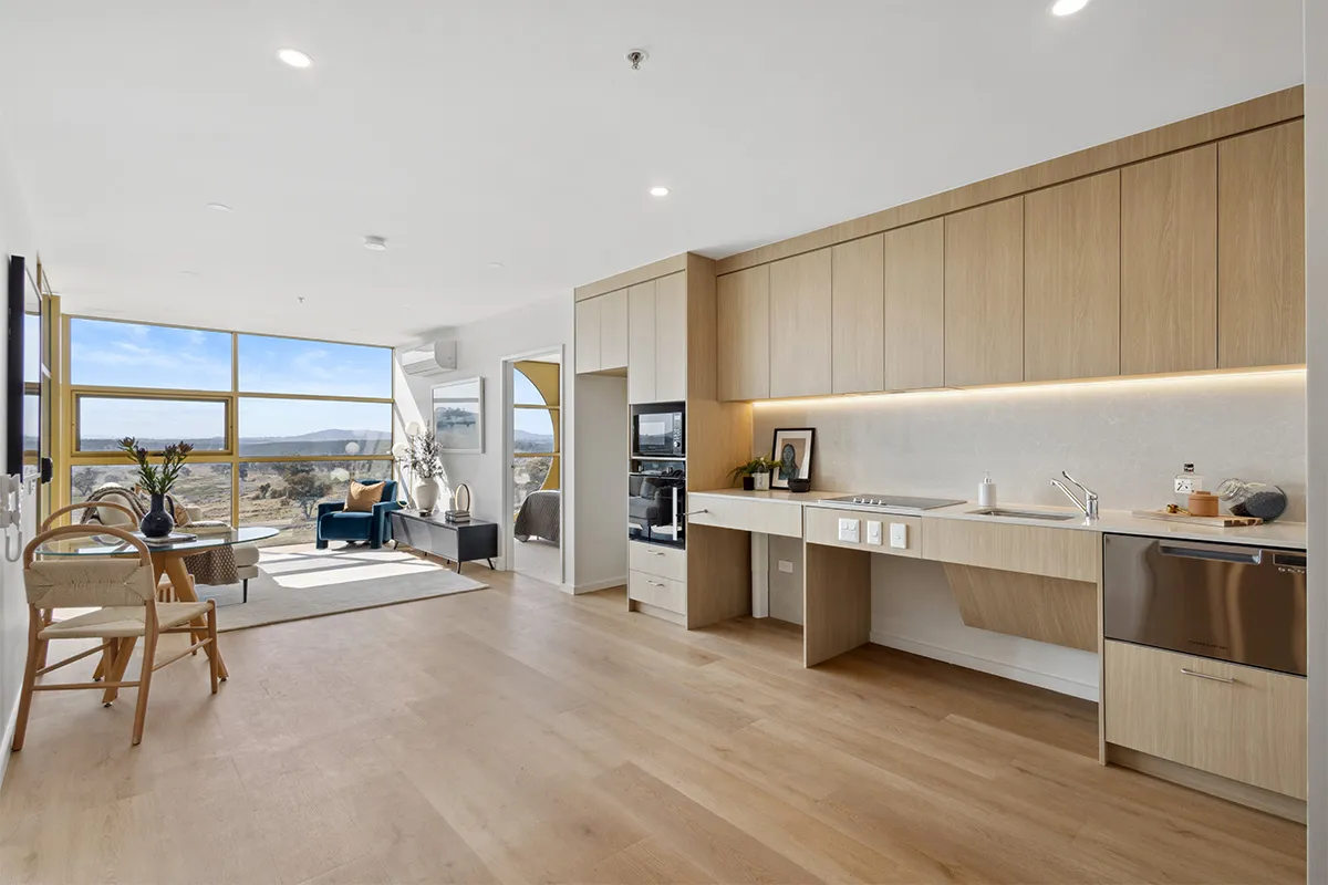 A large kitchen and living room with wooden floors and a view of park land