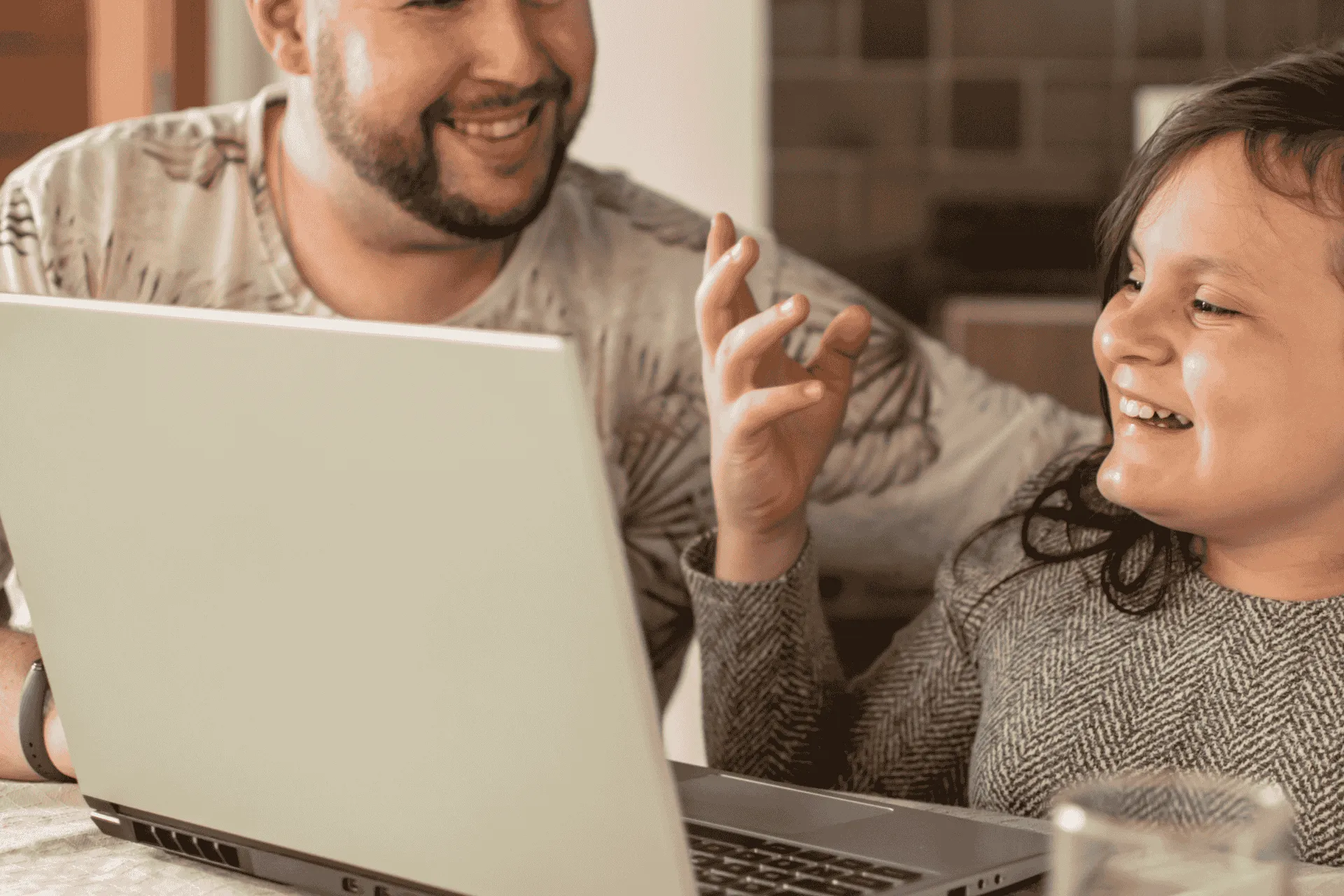 father daughter smiling at computer screen